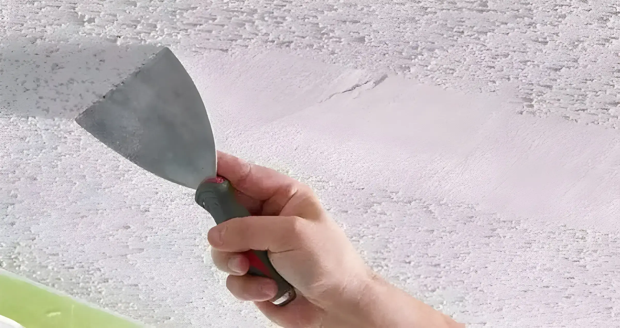 Los Pintores en Murcia eliminando el gotelé con espátula para dejar la pared lisa