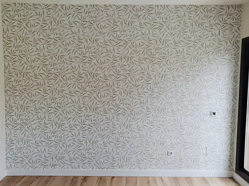 Los Pintores en Murcia colocando papel pintado en pared de acento de habitación luminosa