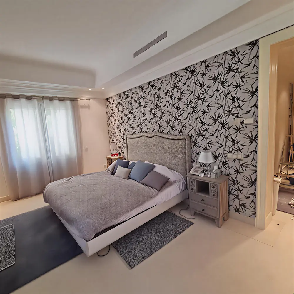 Los Pintores en Murcia instalando papel pintado de hojas en cabecero de dormitorio moderno