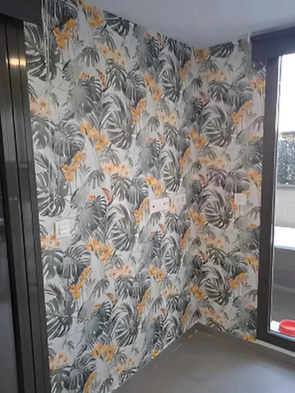 Los Pintores en Murcia colocando papel pintado decorativo en parte de pared en habitación