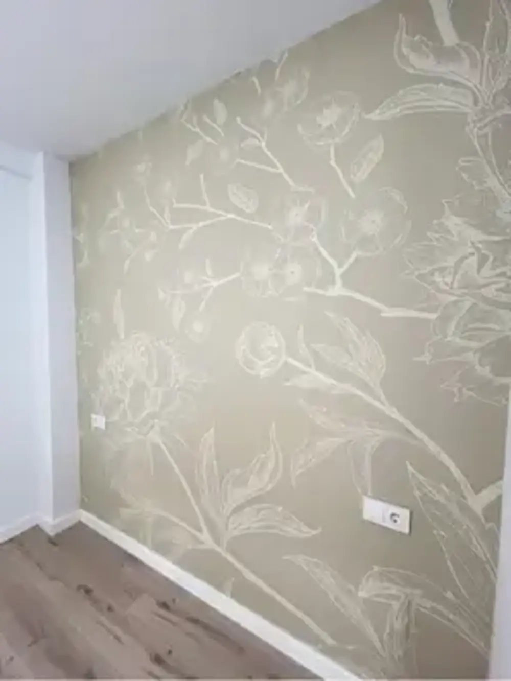 Los Pintores en Murcia aplicando papel pintado de textura clara en habitación reformada